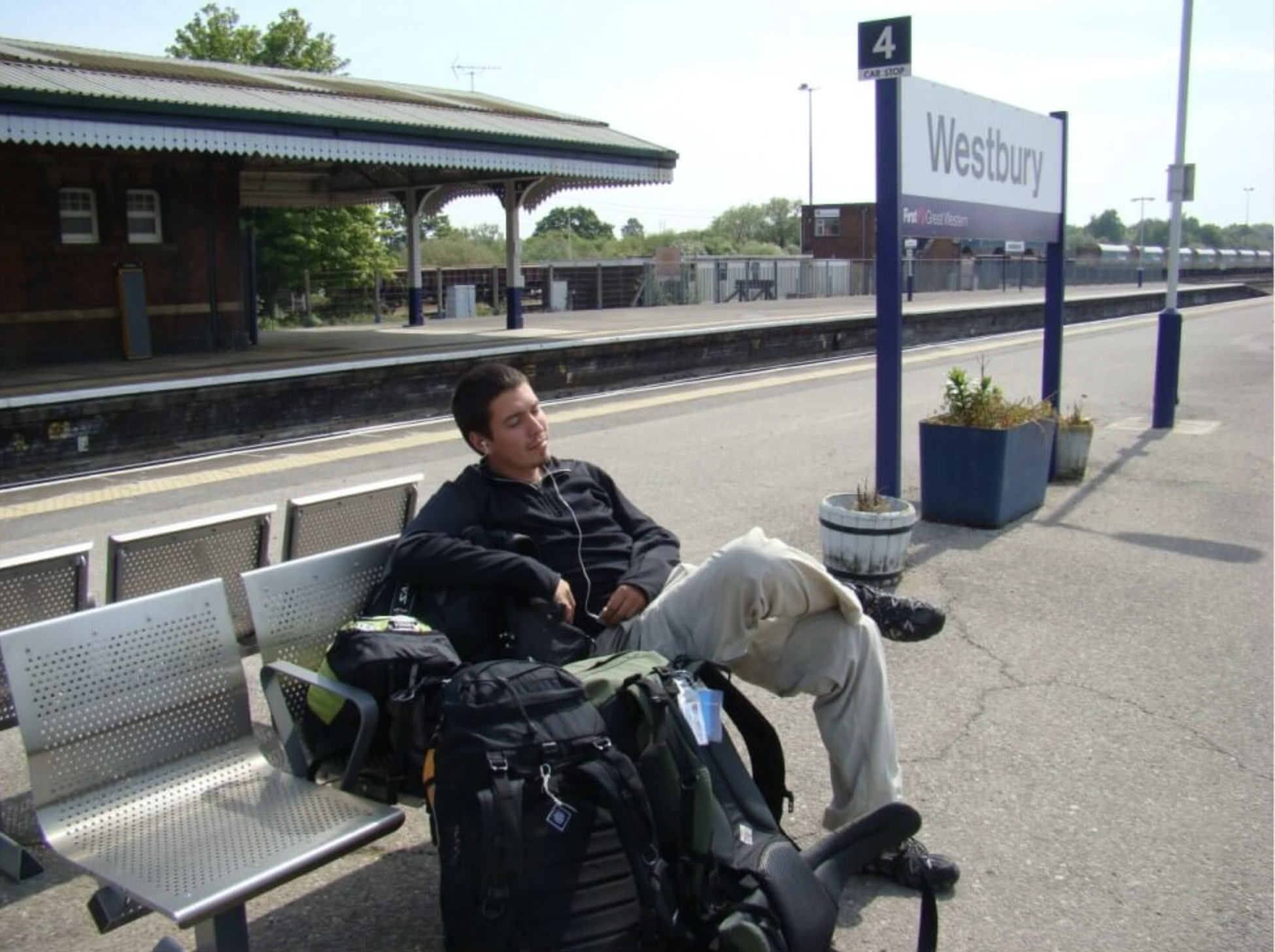 Caco waiting at Westbury station in England with his travel backpack